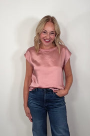 Video of a woman wearing a pink satin cap sleeve top