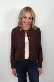 Woman wearing a brown cashmere and silk blend cardigan turning around to show the back of the cardigan.