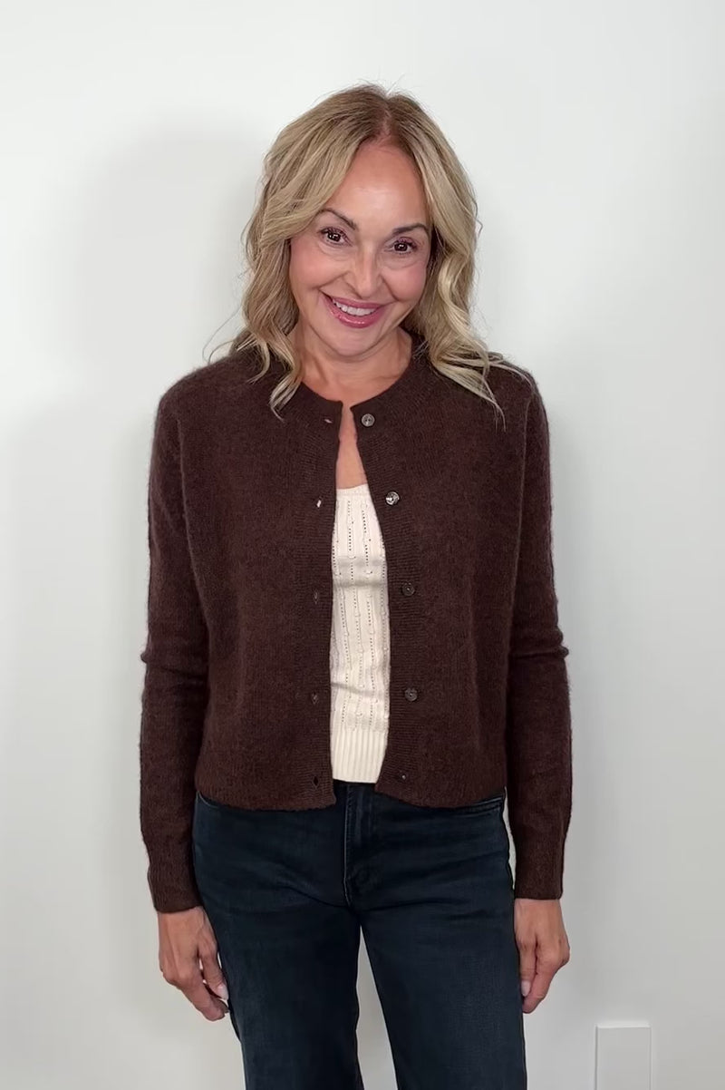 Woman wearing a brown cashmere and silk blend cardigan turning around to show the back of the cardigan.
