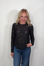 Video of a woman wearing a black burn out long sleeve top