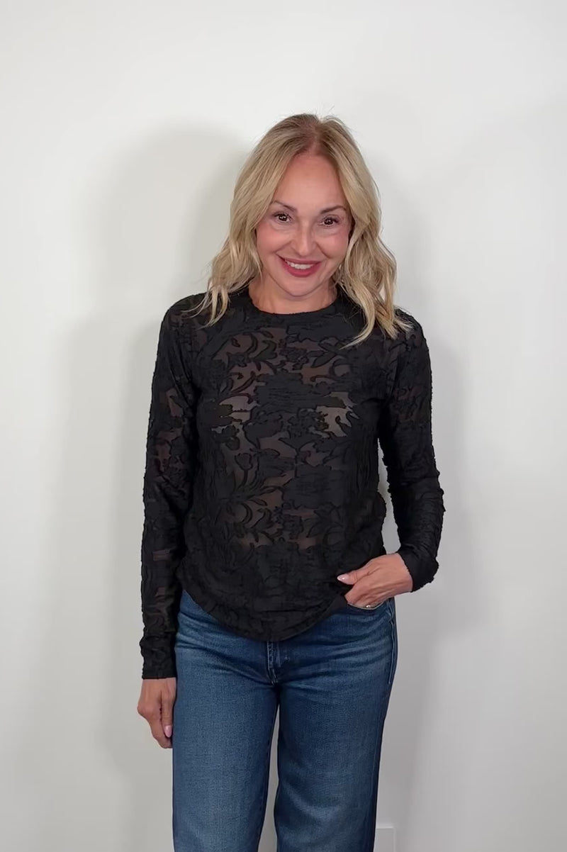 Video of a woman wearing a black burn out long sleeve top