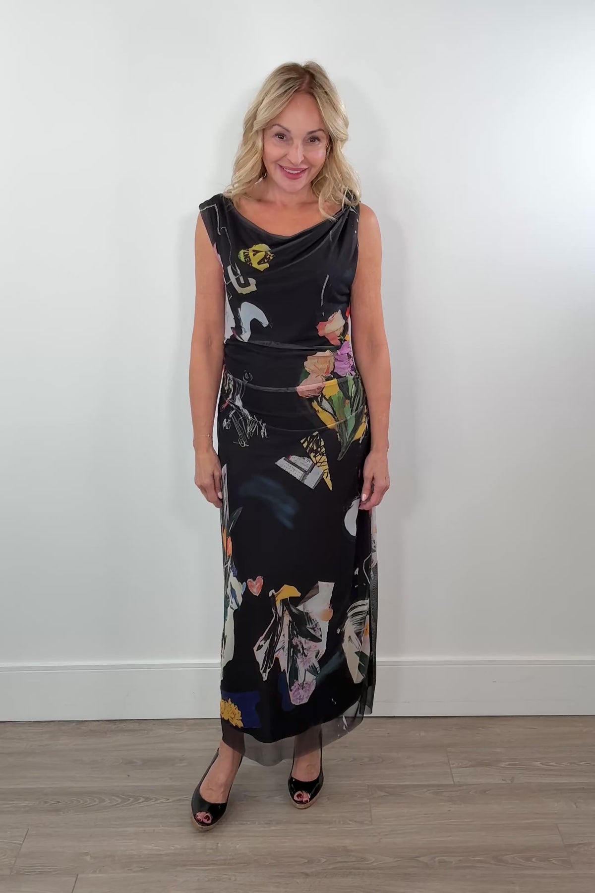 Video of a woman wearing a black maxi lined flower pattern mesh dress with detail in the strap