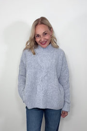Video of woman wearing a high neck light blue knitted sweater 