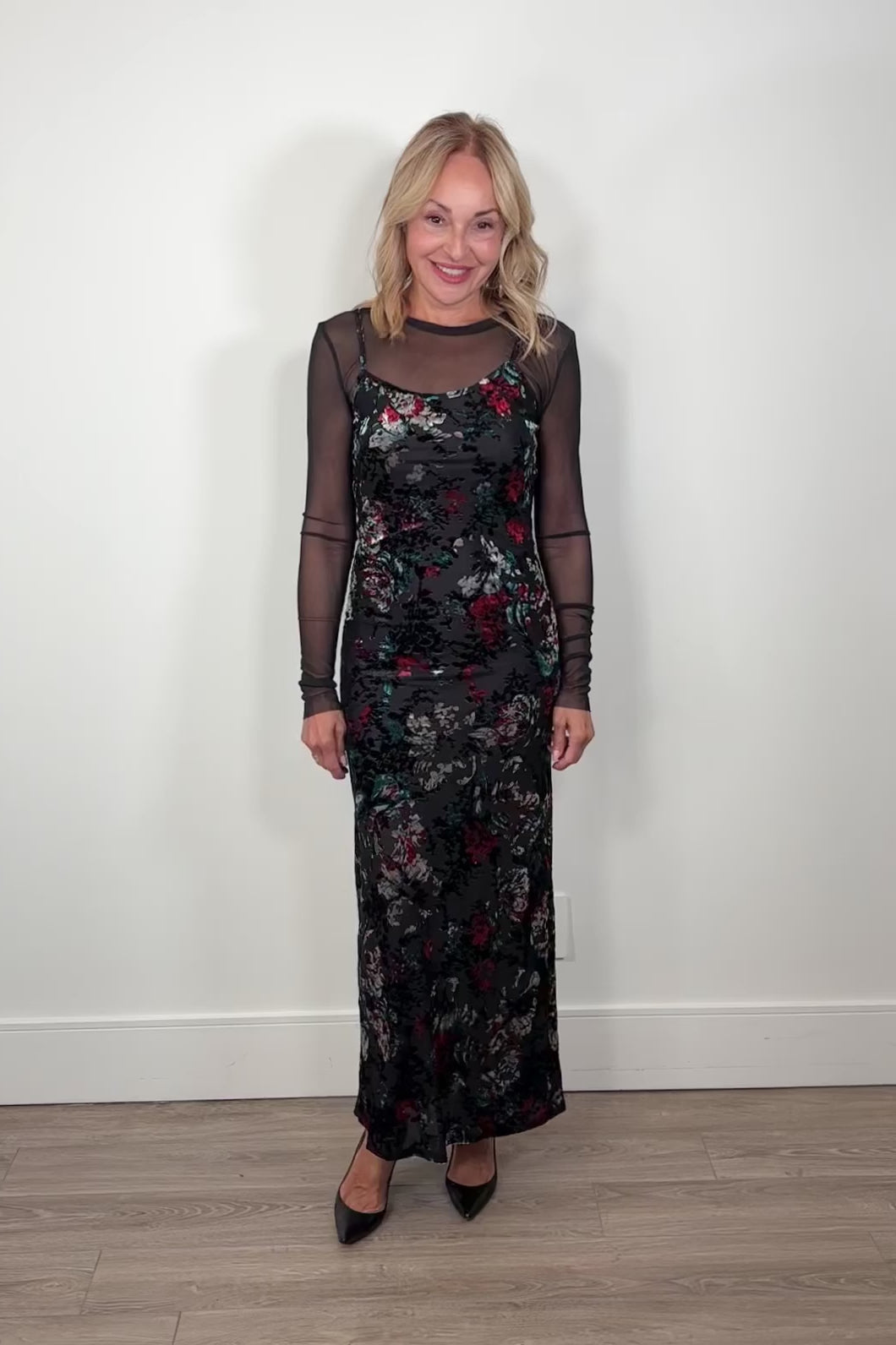 Video of a woman wearing a flora maxi fitted dress with velvet detailing and a long sleeve mesh under tee