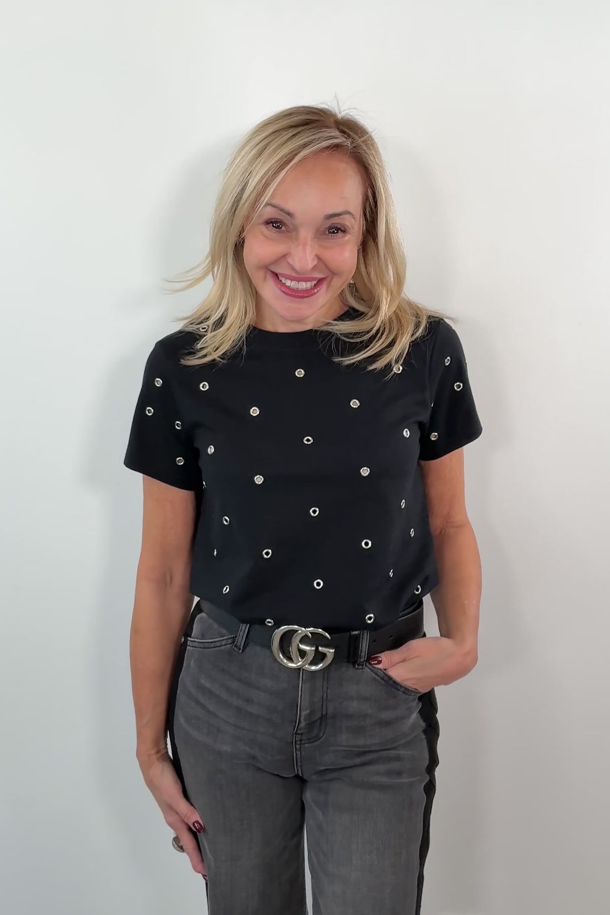 video of a woman wearing a black top with metal embellishments