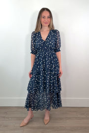 video of a woman wearing a navy midi ruffle dress with white polka dots
