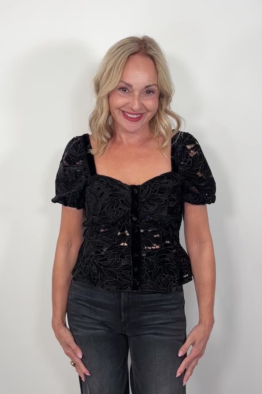 Video of a woman wearing a black lace top