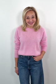 video of a woman wearing a pink sweater and blue jeans 
