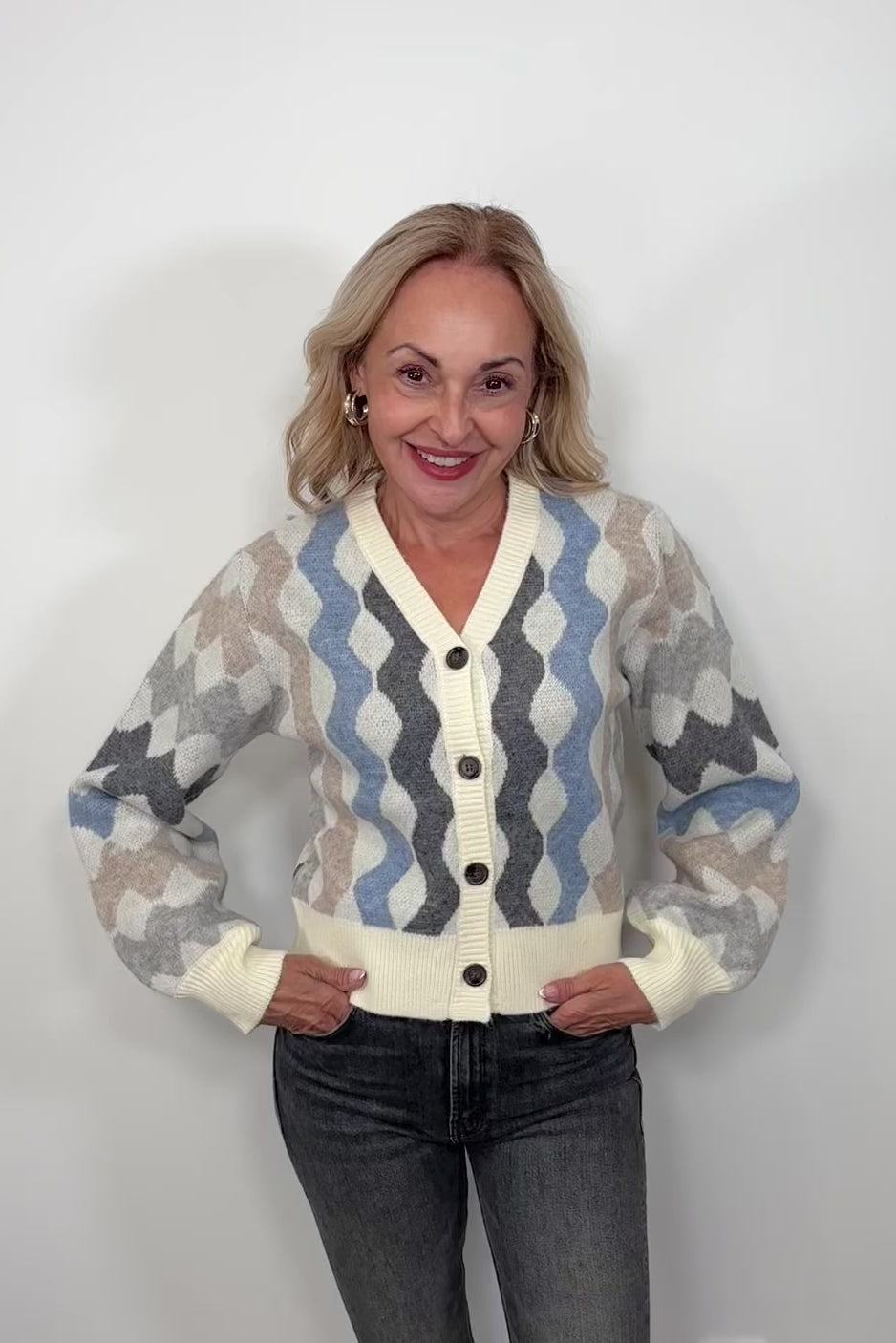 Video of woman wearing a cardigan with blouson sleeved and a multicoloured waive design