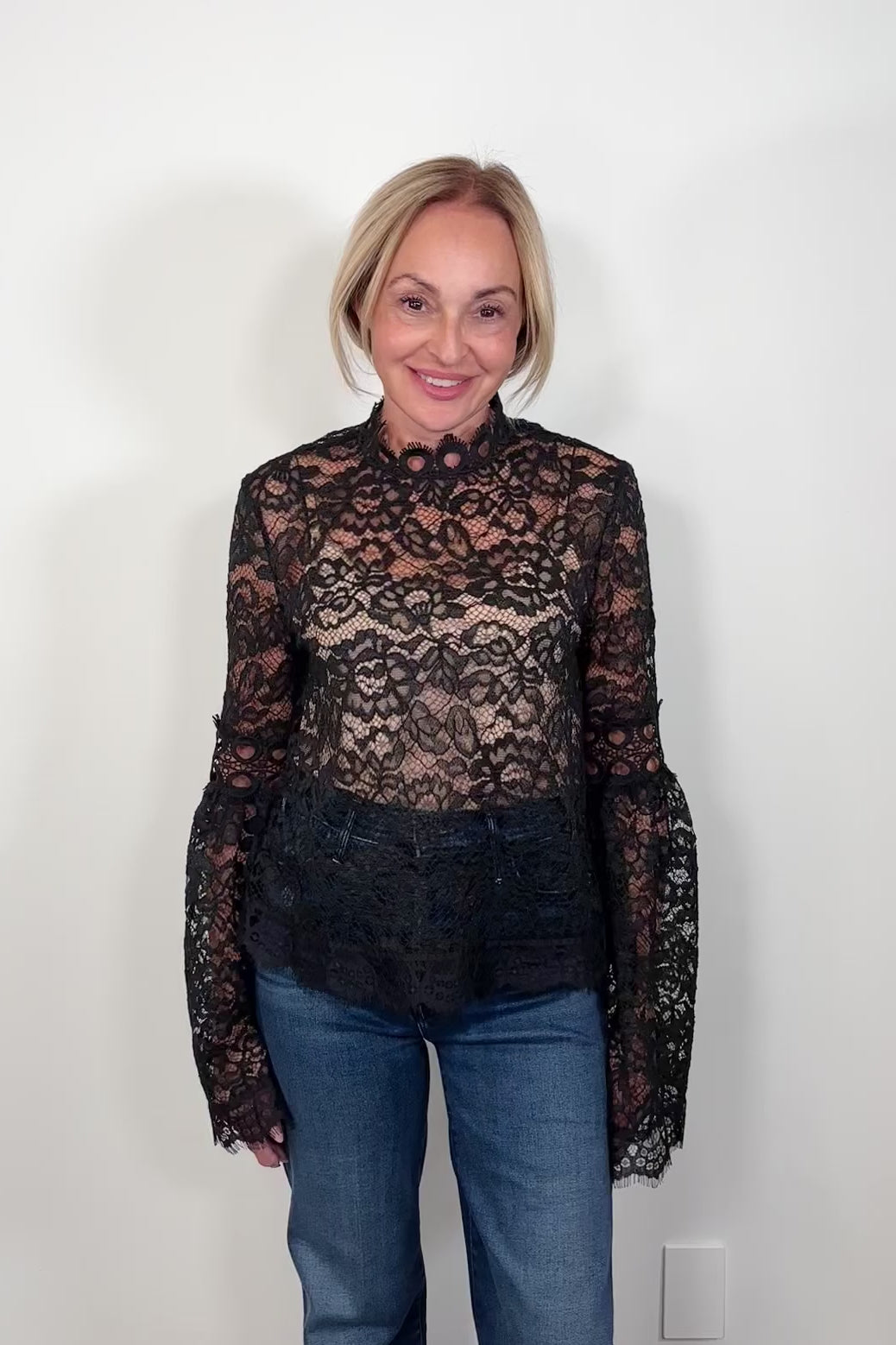 Video of a woman wearing a lace long bell sleeve top