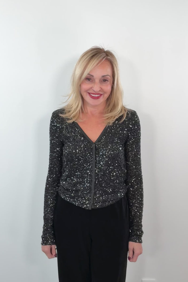 video of a woman wearing a snap on black sequin cardigan