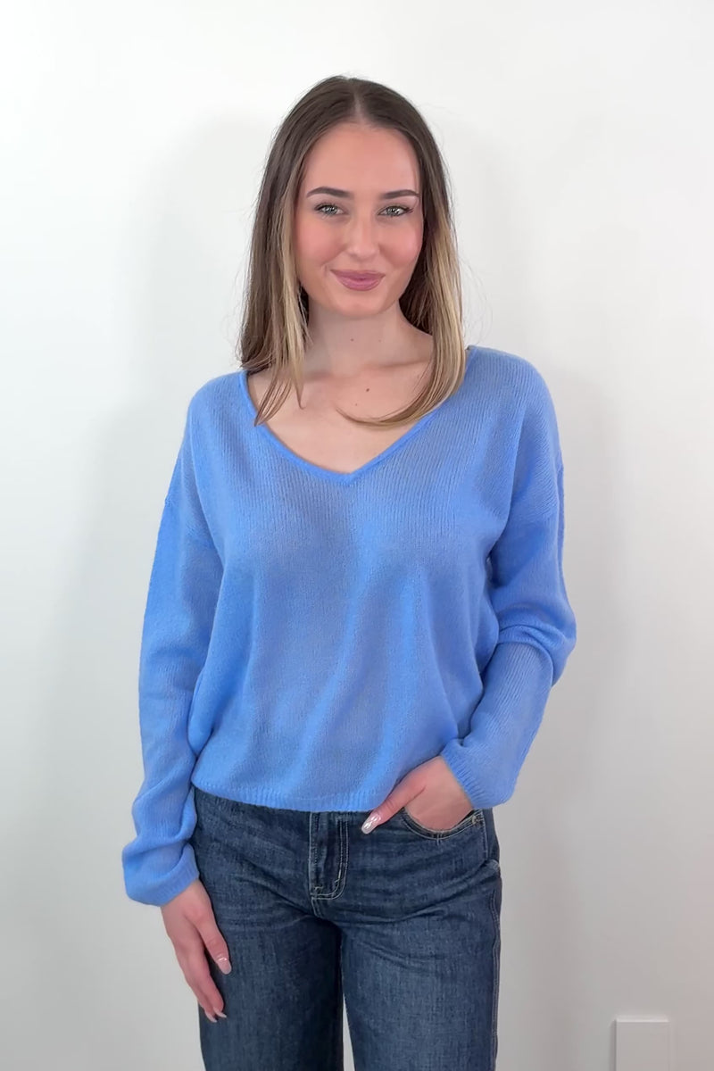 video of a woman wearing blue cashmere sweater with a reversible neckline