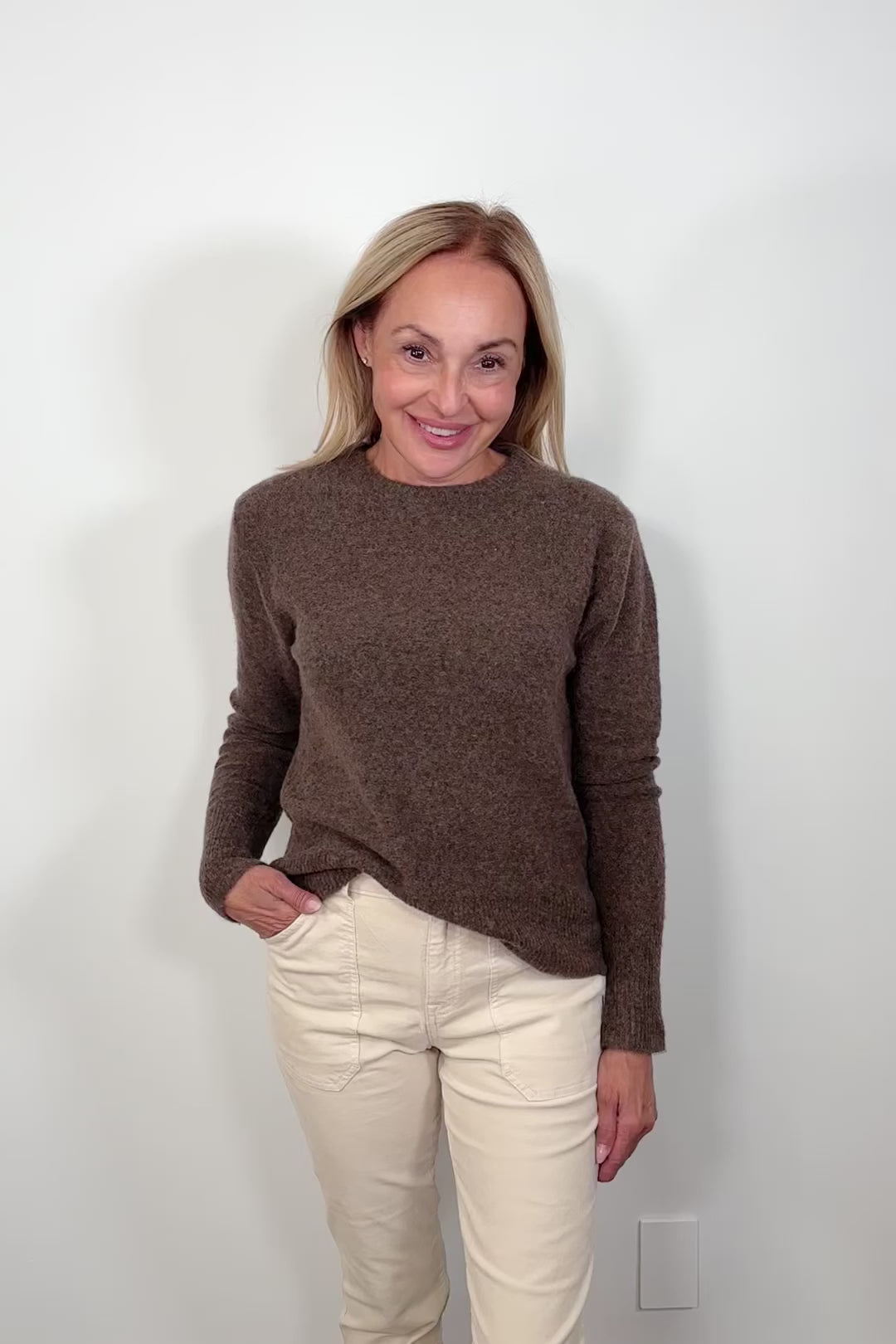 Video of a woman wearing a lightweight brown sweater