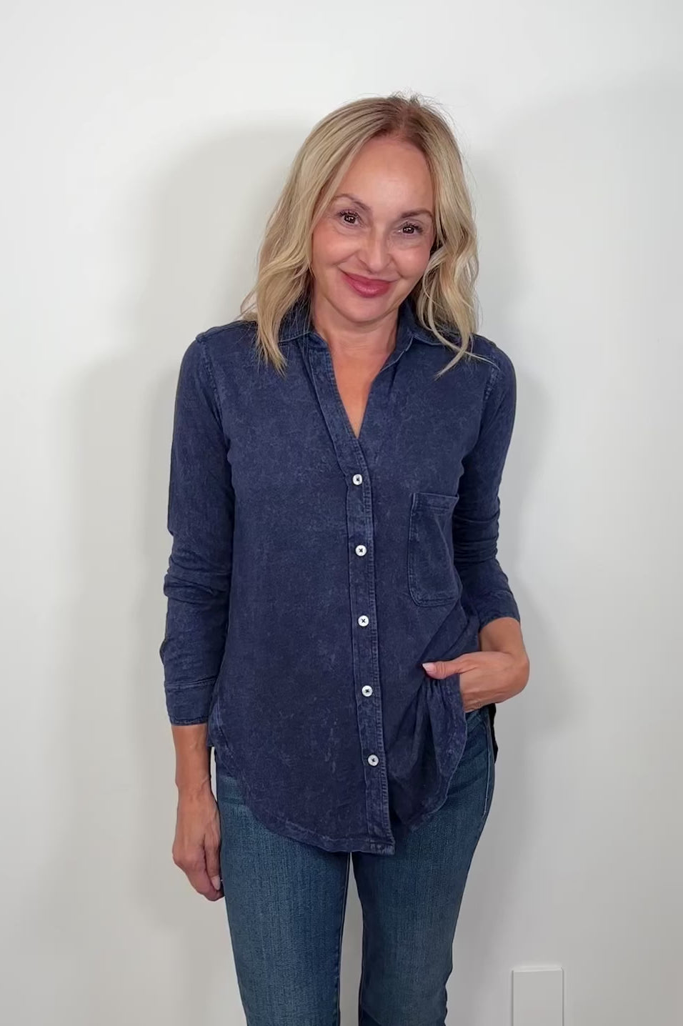 Video of a woman wearing a washed blue button down shirt