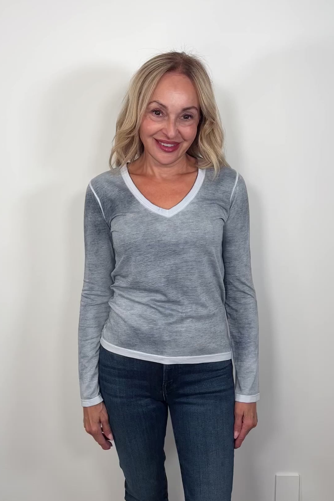 Video of a woman wearing a gray/blue v-neck long sleeve