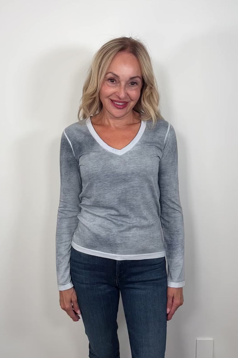 Video of a woman wearing a gray/blue v-neck long sleeve