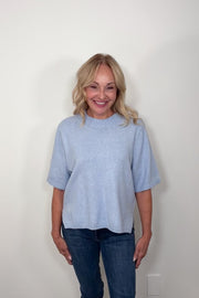 Video of woman wearing a light blue half sleeve sweater