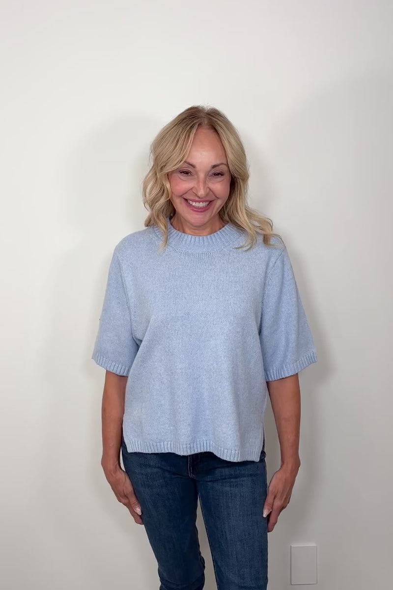 Video of woman wearing a light blue half sleeve sweater