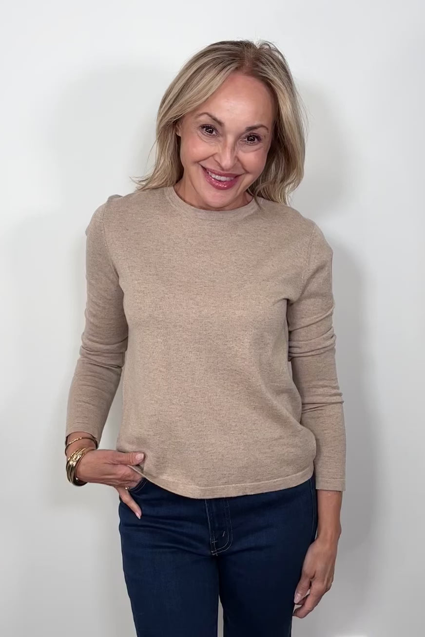Video of a woman wearing a cashmere long sleeve beige shirt