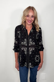 Video of woman wearing a bandana-patterned button down blouse