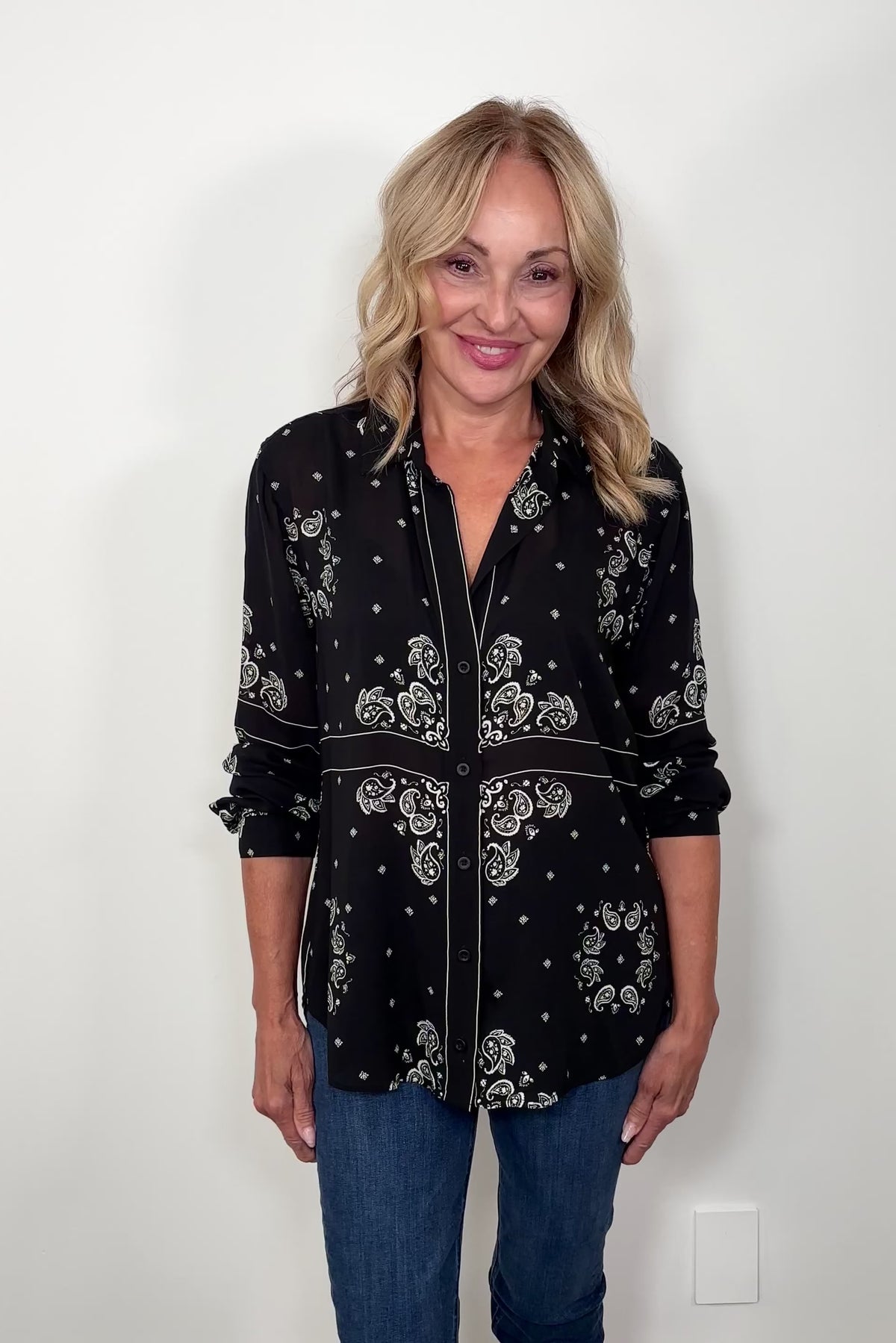 Video of woman wearing a bandana-patterned button down blouse