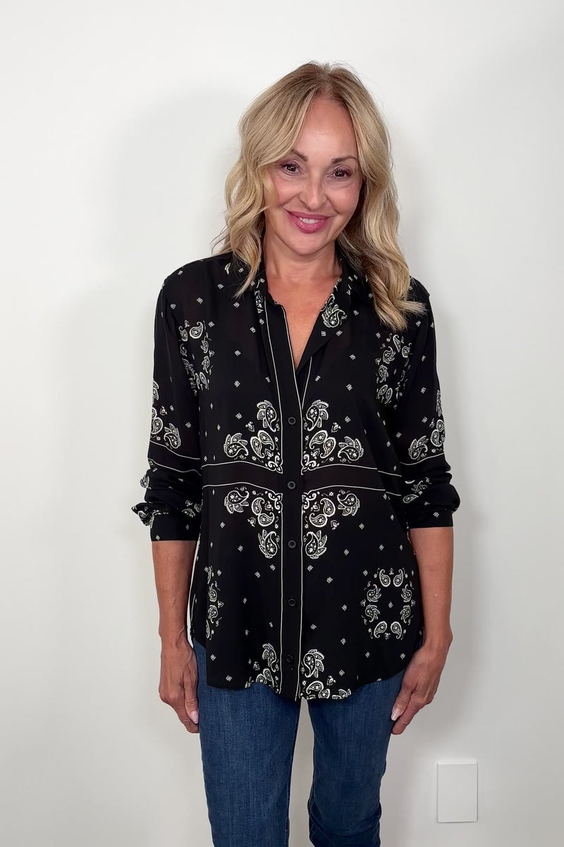 Video of woman wearing a bandana-patterned button down blouse