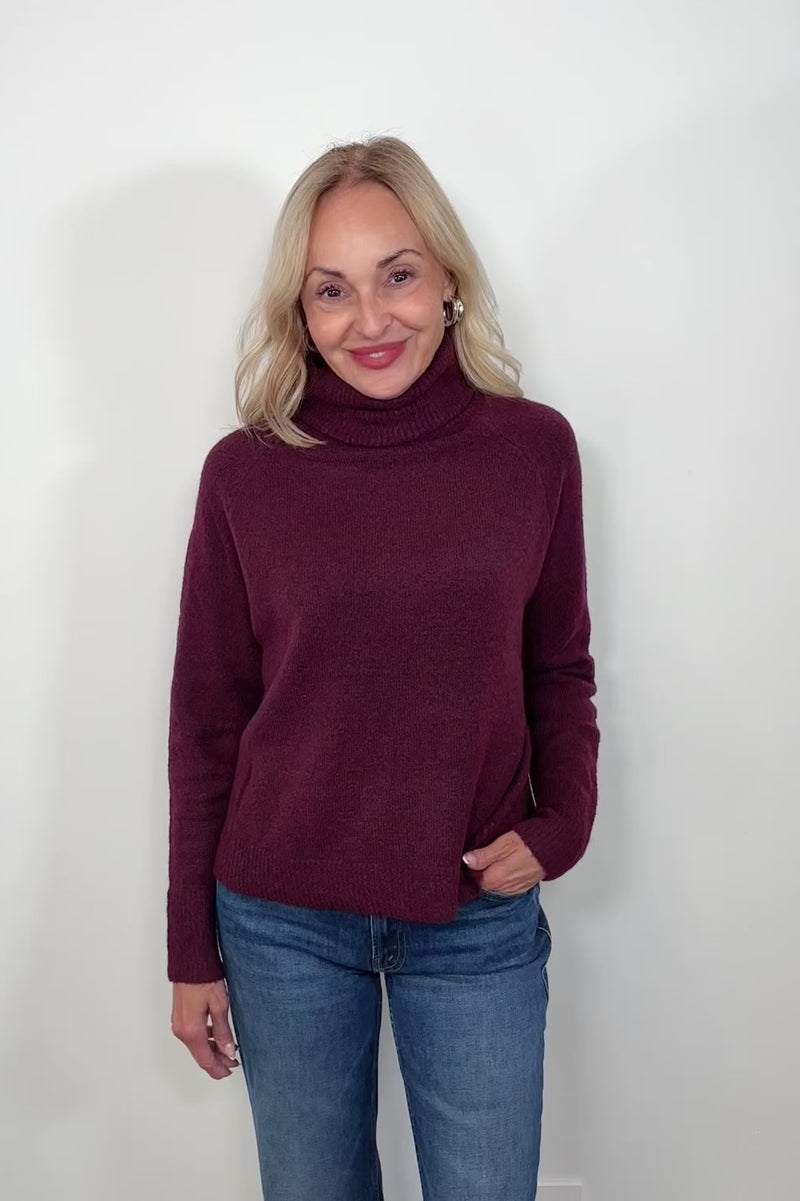 Video of woman wearing an oversized merlot knitted turtleneck 