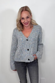 Video of woman wearing an oversized gray and blue cardigan