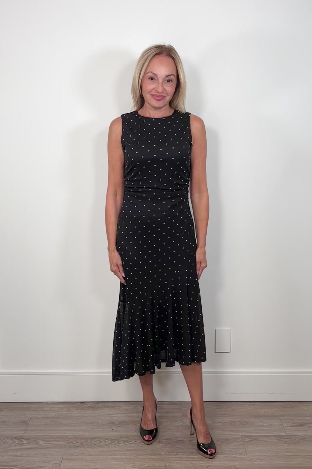 Video of a woman wearing an asymmetrical polka dot midi dress