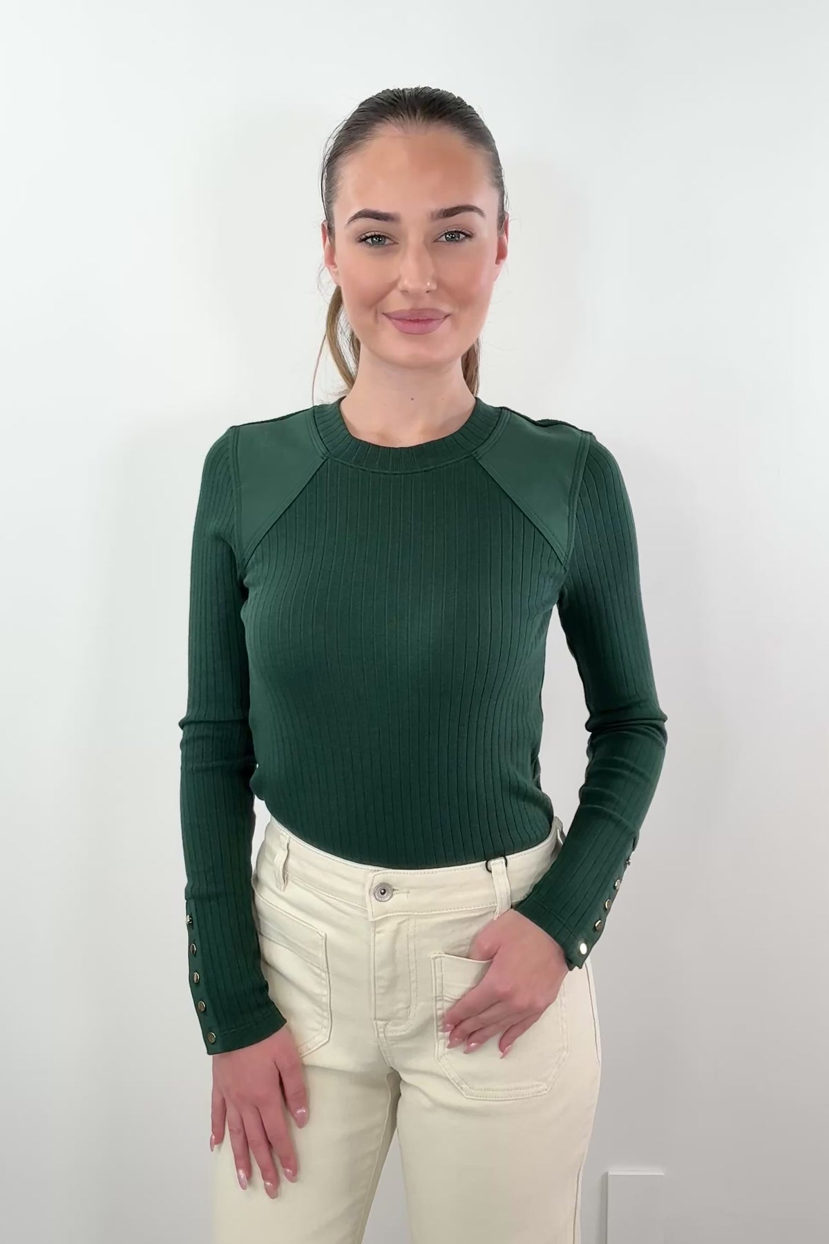 video of woman wearing green knitted longsleeve with gold hardware details on cuffs