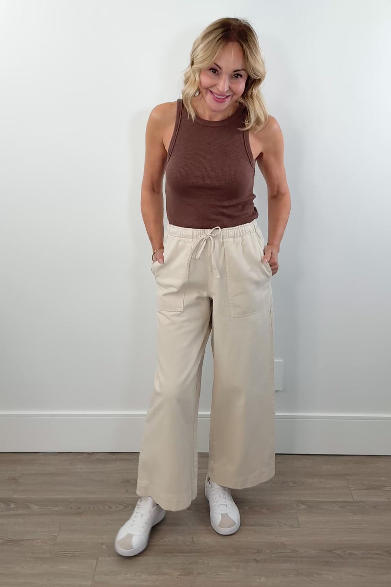 video of woman wearing beige wideleg trackpants