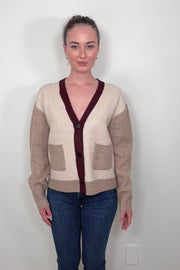 Video of woman wearing a colour block beige and burgundy cardigan with pockets