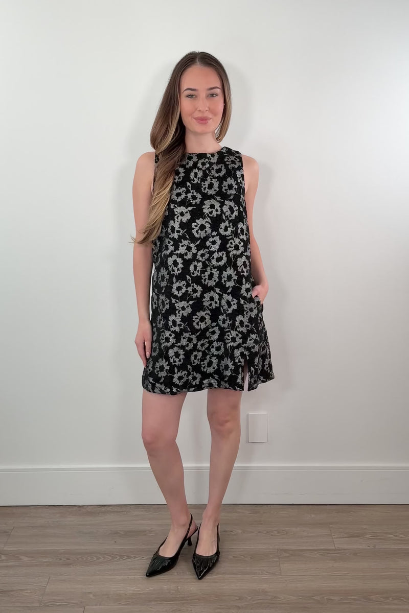 video of a woman wearing a black dress with silver flower partner