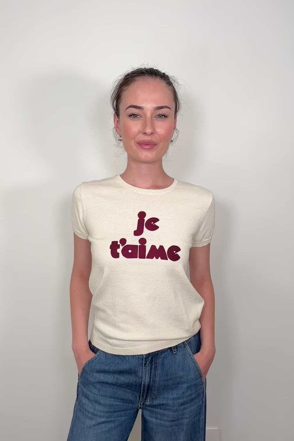 Video of woman wearing a knitted tee shirt with text on it
