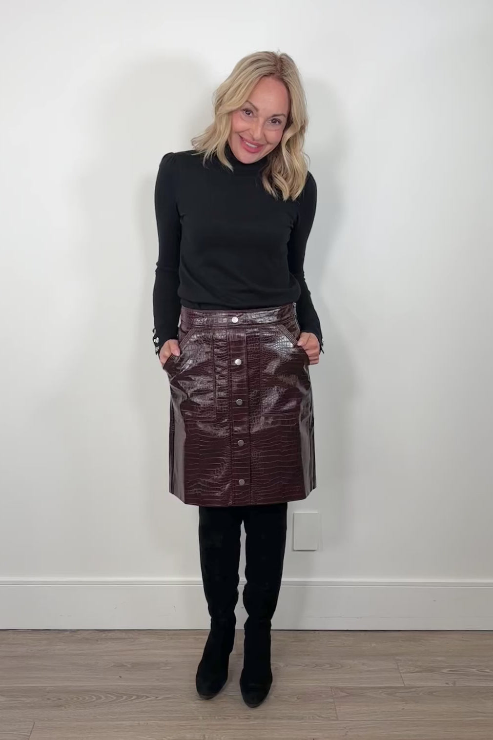 video of a woman wearing a short burgundy button front Russi leather skirt