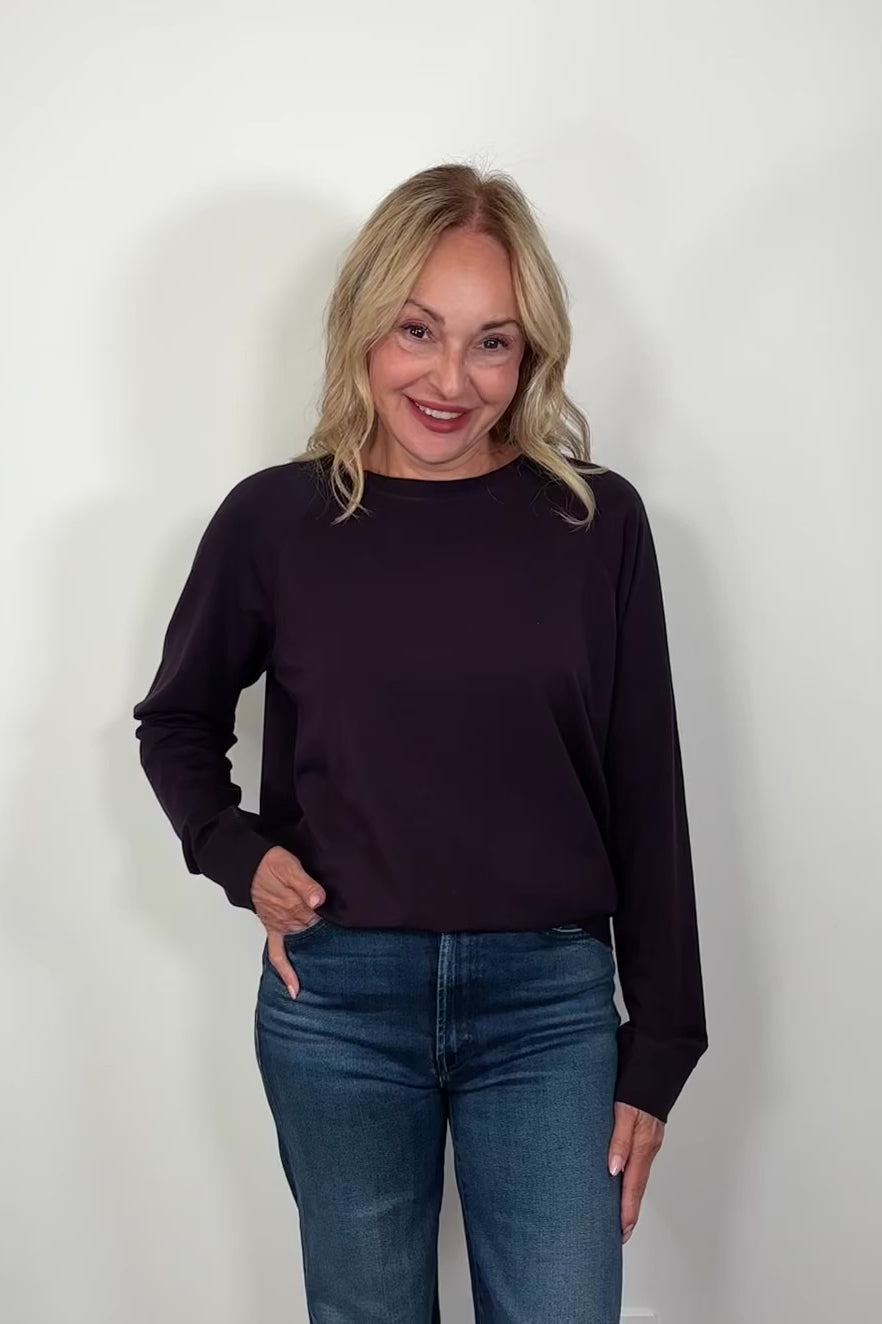 Video of a woman wearing a deep purple cotton sweatshirt
