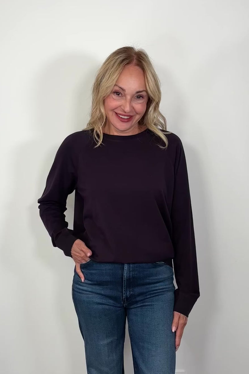 Video of a woman wearing a deep purple cotton sweatshirt