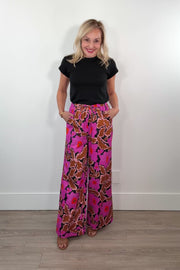 video of a woman wearing wide leg neon pink floral pants