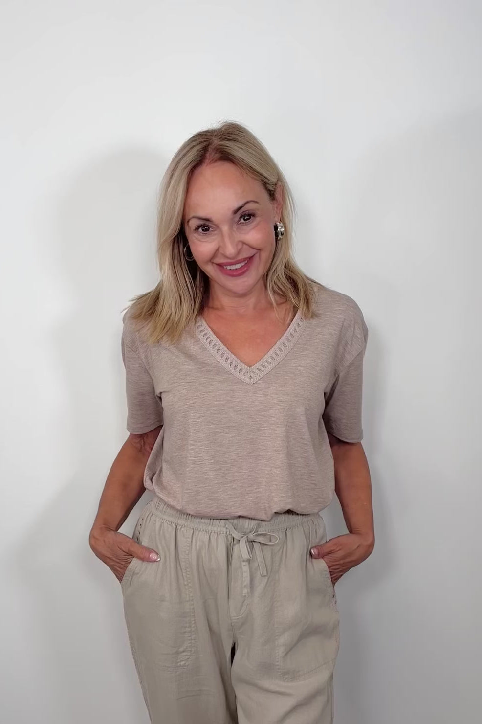 Video of woman wearing a cool beige v-neck tee