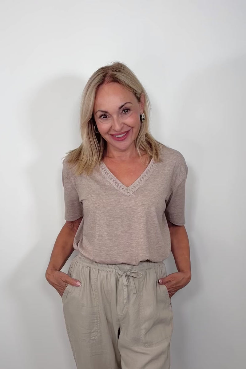 Video of woman wearing a cool beige v-neck tee