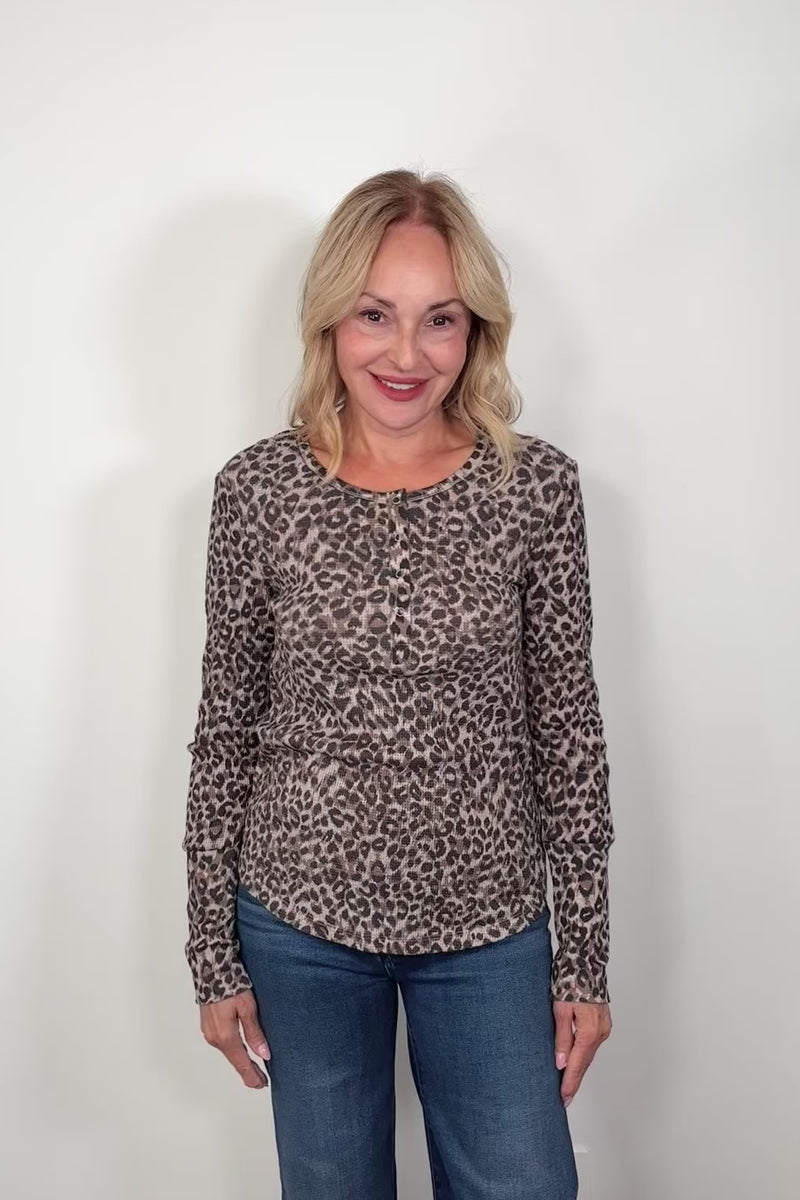 Video of a woman wearing a leopard print henley