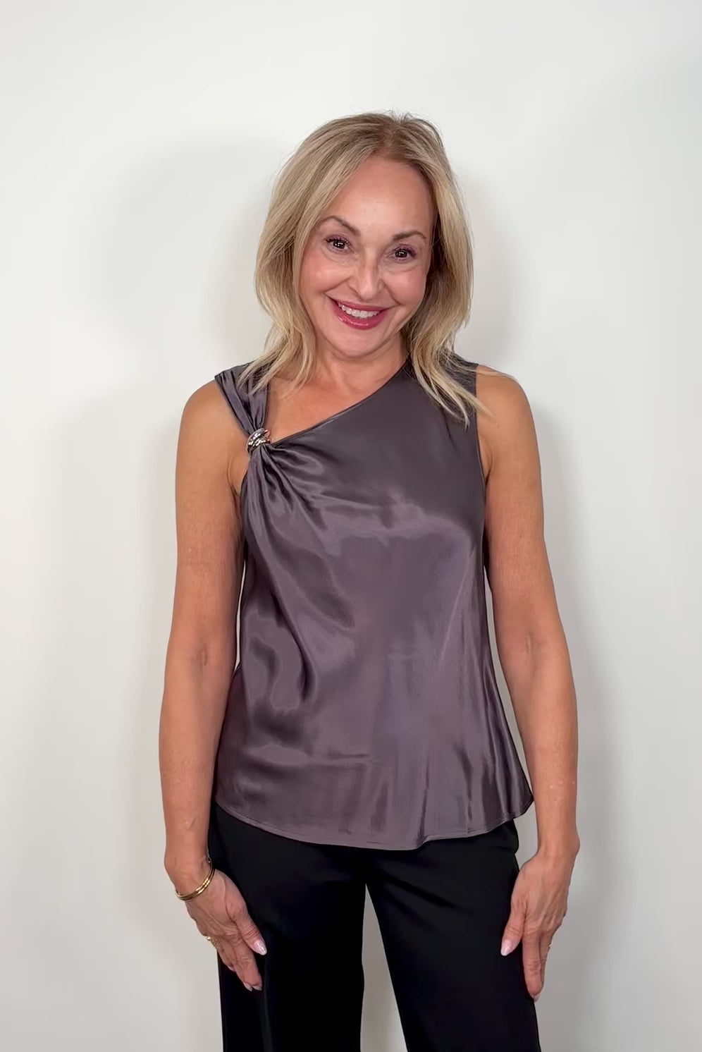 Video of woman wearing a deep metallic gray satin tank top with a silver metal detail