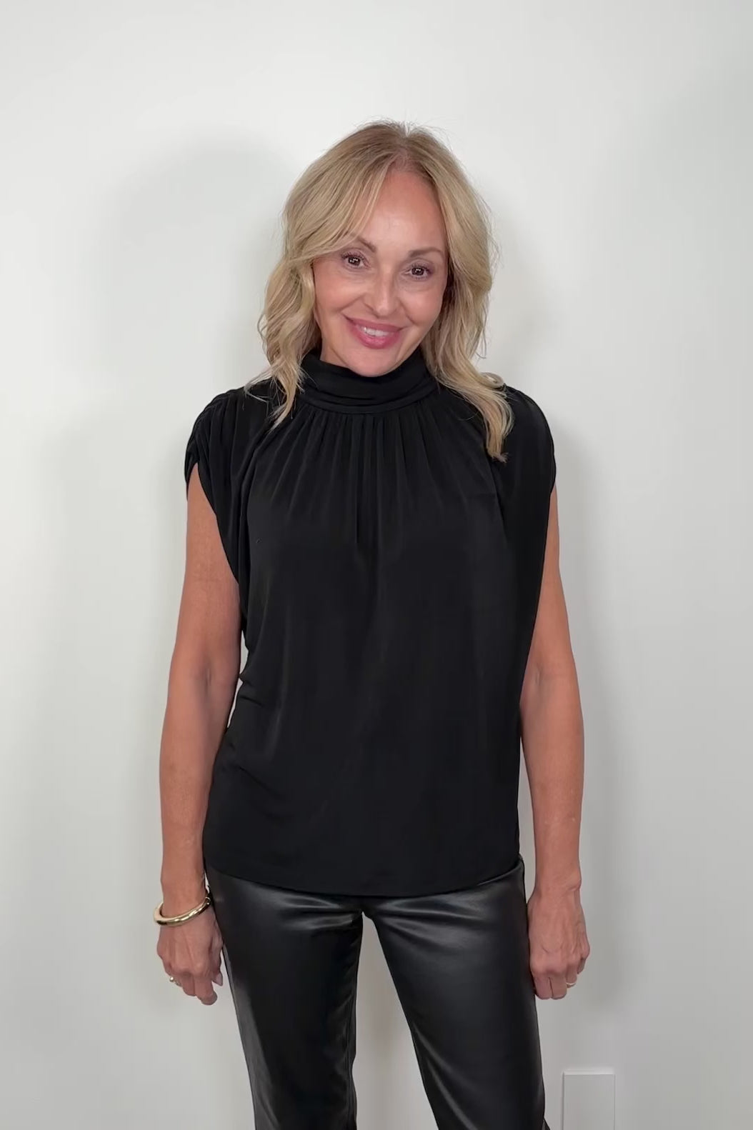 video of a woman wearing a black mock neck top