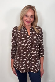 Video  of woman wearing a brown silk blouse with a white horse pattern all over 