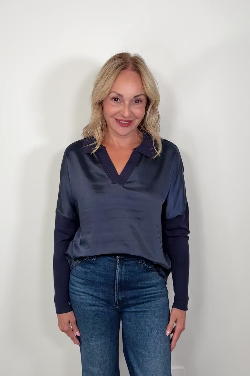 Video of a woman wearing a navy jersey and satin long sleeve collared too