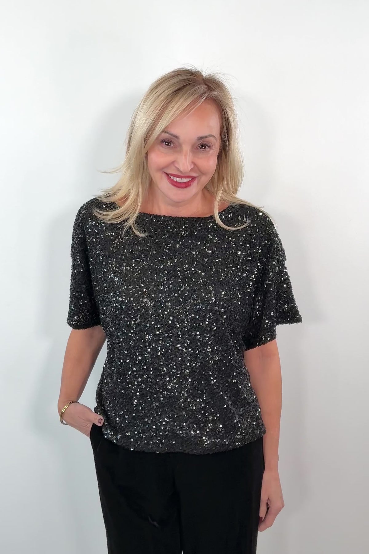 video of a woman wearing an oversized black sequin top 