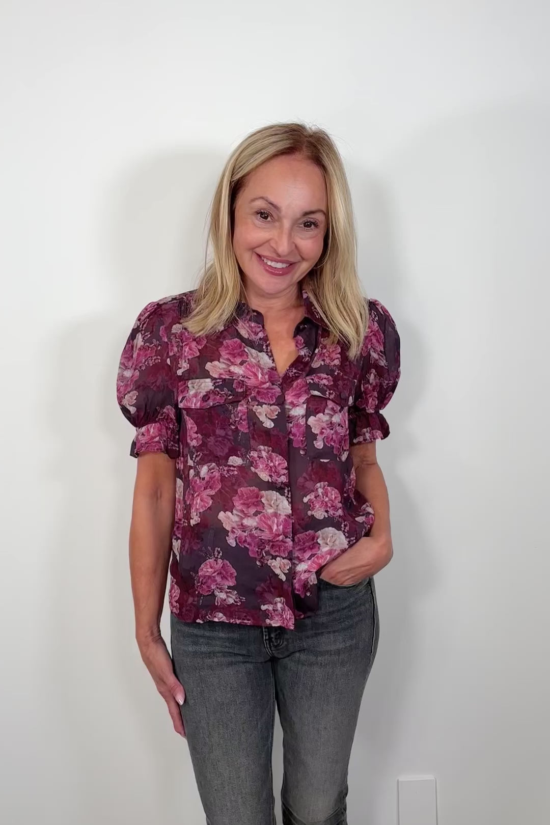 Video of woman wearing a see through collared button up floral shirt