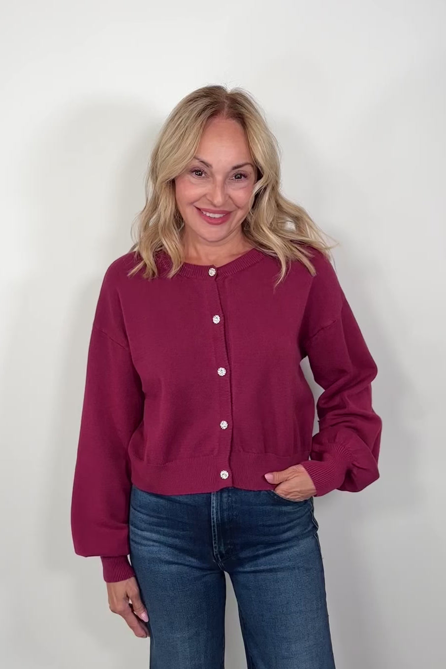 Video of a woman wearing a burgundy crystal button cardigan