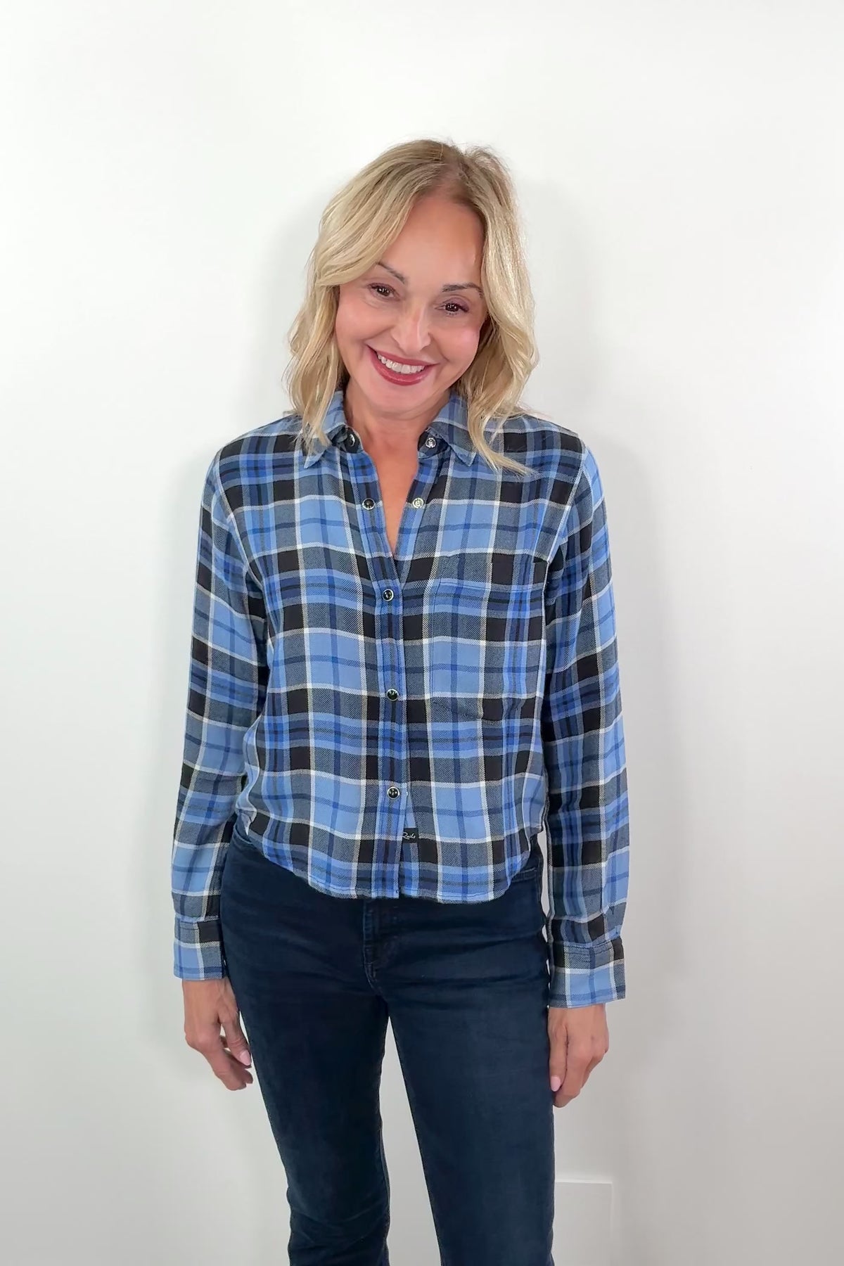 video of a woman wearing a blue plaid shirt with snap buttons