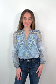 video of a woman wearing a blue paisley patterned silk ruffle blouse